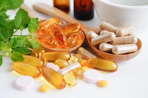 medicina alternativa cápsula orgánica a base de hierbas con vitamina e omega 3 aceite de pescado, mineral, medicamento con hojas de hierbas suplementos naturales para una vida sana y buena. foto