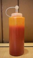 Vibrant Red Chilli Sauce in Clear Container for food topping. photo