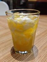 Refreshing A Glass of Coconut and Orange Fusion Drink on Wooden Table photo