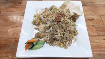 Savory Seafood Fried Rice on White Plate with Wooden Table Background photo