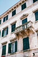 Old stone building with a balcony and green shutters on the windows. Kotor, Montenegro photo