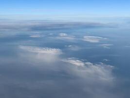 White cirrus clouds on a bright turquoise sky. Top view photo