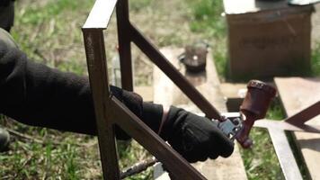 Craftsman paints a metal structure using a spray gun. Worker applies paint with paint sprayer and compressor video