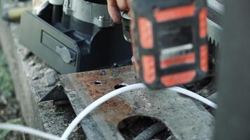 Close up of Drill bit Drilling into metal Pipe. Drilling a hole in the square steel pipe video