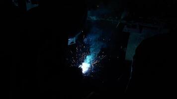 Welder Welds a metal pipe. Iron welding. Welding Sparks video