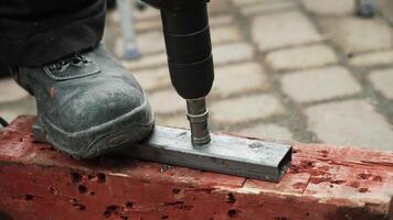 Close up of Drill bit Drilling into metal Pipe. Drilling a hole in the square steel pipe video