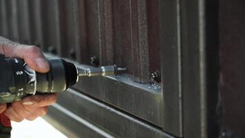 Close up of Drill bit Drilling into metal Pipe. Drilling a hole in the square steel pipe video