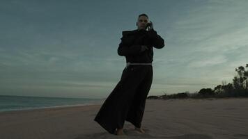 Monk On The Phone At The Beach Near The Ocean video