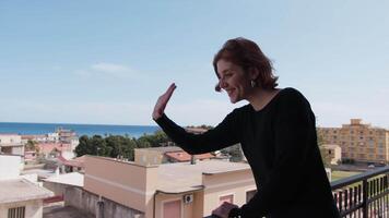 kvinna klädd i svart hälsar henne grannar från de balkong video