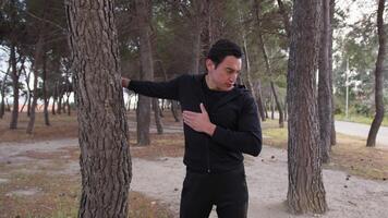 Man Does Stretching Chest In The Pine Forest In A Park video