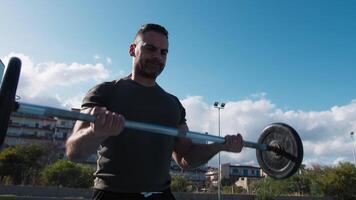 Man Trains With Barbell Outside For Biceps video