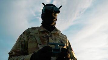 homem dentro militares uniforme com vr fone de ouvido pilotos uma zangão ao ar livre para mísseis video