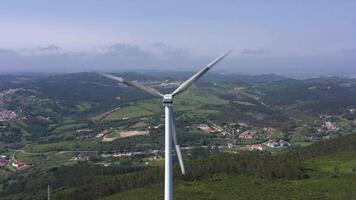 vento turbina com lâminas dentro verde rural área dentro Portugal em ensolarado dia. aéreo visualizar. alternativo renovável energia. órbita video