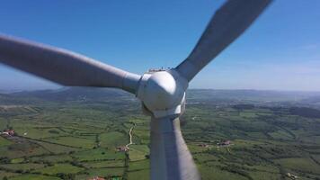 vent turbine avec lames dans vert rural zone sur ensoleillé journée dans le Portugal. aérien voir. alternative renouvelable énergie. drone se déplace en arrière lentement video