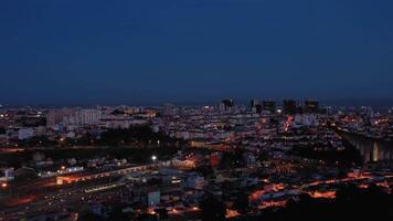 iluminado Lisboa horizonte a noche. Portugal. aéreo vista. zumbido se mueve oblicuo video