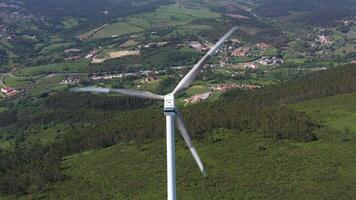 vento turbina con lame nel verde rurale la zona nel Portogallo su soleggiato giorno. aereo Visualizza. alternativa rinnovabile energia. fuco si sposta verso il basso, inclinazione su video
