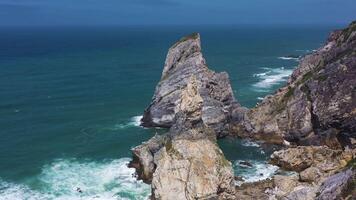 Ursa Beach, Two Sea Stacks, Cliffs and Atlantic Ocean Waves on Sunny Day. Portugal. Aerial View. Orbiting, Tilt Up video