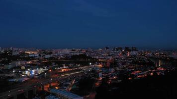 iluminado Lisboa horizonte a noche. Portugal. aéreo vista. zumbido se mueve hacia arriba video