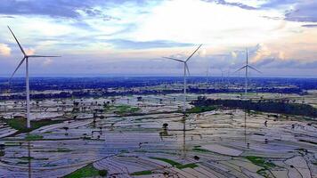 Aerial view of a wind turbine farm with rice paddies and a beautiful sky video