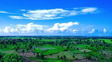 aéreo Visão do uma vento turbina Fazenda com arroz arrozais e uma lindo céu video