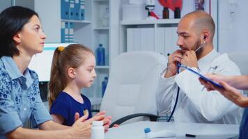 cuidando médico médico consultante niña en oficina con estetoscopio comprobación aliento. especialista en medicina Proporcionar salud cuidado Servicio consulta diagnóstico examen tratamiento en hospital gabinete video