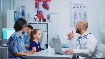 Doctor and patients looking at x-ray sitting in medical office. Physician specialist in medicine providing health care services consultation, radiographic treatment in clinic hospital cabinet video