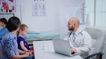 Doctor examining child x-ray and talking with mother. Healthcare practitioner physician specialist in medicine providing care services consultation, radiographic treatment in clinic hospital cabinet video