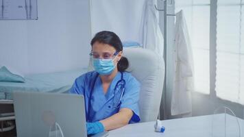 enfermero mecanografía en ordenador portátil vistiendo médico guantes durante coronavirus. médico médico especialista en medicina Proporcionar salud cuidado servicios consulta tratamiento examen en hospital gabinete video