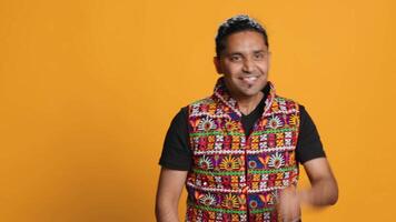 Portrait of narcissistic cheerful indian man celebrating and bragging, showing arrogance. Satisfied person boasting about achievement, cheering and gesticulating, studio background, camera A video