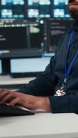 Vertical Proficient technician overseeing server room, running code on computer, troubleshooting servers. Software developer upgrading hardware clusters, networking systems and storage arrays video