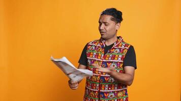 Indian man browsing though financial audit report files, throwing them in anger, feeling overworked, studio background. Stressed worker annoyed by paperwork, refusing to work anymore, camera B video