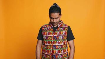 Portrait of happy man waving hand, saluting, gesturing, isolated over studio background. Cheerful indian person in traditional clothing doing greeting hand gesture, camera B video