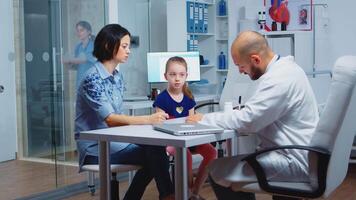 Pediatrician writing prescription for kid after examination. Healthcare practitioner, physician, specialist in medicine providing health care services consultation diagnostic treatment in hospital. video