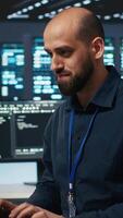 Vertical Hardworking engineer feeling happy and celebrating after being able to repair damages in data center facility. Cheerful man pleased after using PC to fix server cabinets errors video