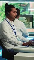 Vertikale indisch Anruf Center Operator versammelt sich Ort und Geographisches Positionierungs System Koordinaten, Überwachung der Verkehr über Überwachung Kamera System. Mitarbeiter mit cctv echt Zeit Aufnahmen zu sammeln Daten. Kamera a. video
