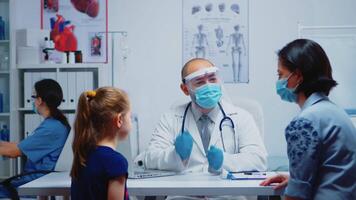 médico trabajador con proteccion máscara explicando radiografía de padre durante coronavirus. especialista en medicina Proporcionar salud cuidado servicios consulta, radiográfico tratamiento en clínica gabinete hospital video