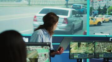 Supervisor gathering intelligence from satellite based surveillance footage, diverse team of operators analyzing traffic through security cameras. Control center license plate reading. Camera A. video