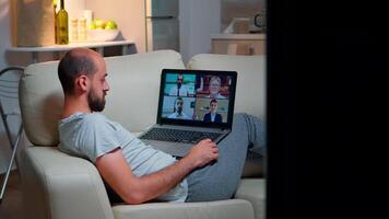 müde Mann im Pyjama Sitzung auf Sofa fallen schlafend während haben online Geschäft Videoanruf mit Teamkollegen mit Laptop Computer. kaukasisch männlich auf Konferenz Internet Netz Kommunikation video