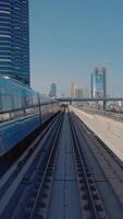 treno conduttore autista punto di Visualizza di in movimento la metropolitana rotaia treno nel un' città fra edifici 4k video