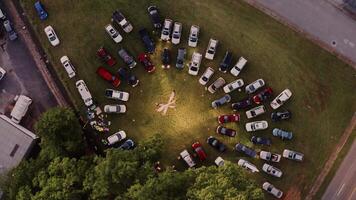 4K Top areal view of spectators watching dance performance from inside cars. Cars parked in a circular pattern video