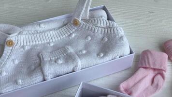 Baby and child clothes and knitted toys in carton box. video