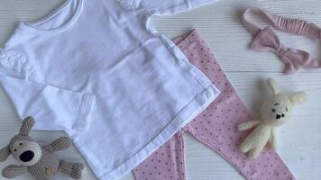 Set of baby bodysuits, pants, socks and knitted toy video