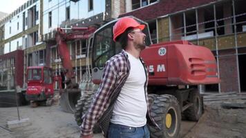 Caucasian man builder wearing shirt safety helmet, got good promotion or good news, and enjoyed very much happy bouncing, with his fists clenched and big smile at construction site. video