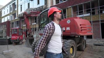 caucásico hombre constructor vistiendo camisa la seguridad casco, tiene bueno promoción o bueno noticias, y disfruté muy mucho contento rebote, con su puños apretado y grande sonrisa a construcción sitio. video