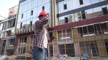 engenheiro construtor tendo café pausa às construção local. caucasiano homem com Leve embora café copo e protetora engrenagem tem pausa enquanto trabalhando em local. construção trabalhador bebendo café. video