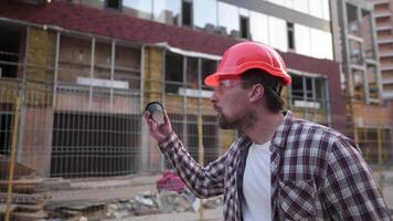 Bearded man builder emotion facial expression gesturing hands at construction site. Architect in helmet angry and insane, waving hands disappointed and furious, screaming anger, rage and aggressive. video