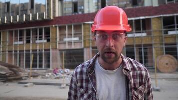 jovem arquiteto inspetor às construção site, vestindo construção trabalhador segurança capacete, irritado e frustrado, gritando dentro raiva, louco e gritando com elevado mão, raiva conceito. video