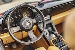 Vicenza Italy 19 March 2024 Close up photo featuring the vintage charm of an Alfa Romeo Duetto s steering wheel and dashboard