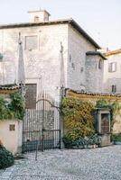 Wrought iron gate of an ancient mansion with stone sculptures photo