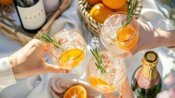 People are holding up two glasses of a drink with orange slices in them photo